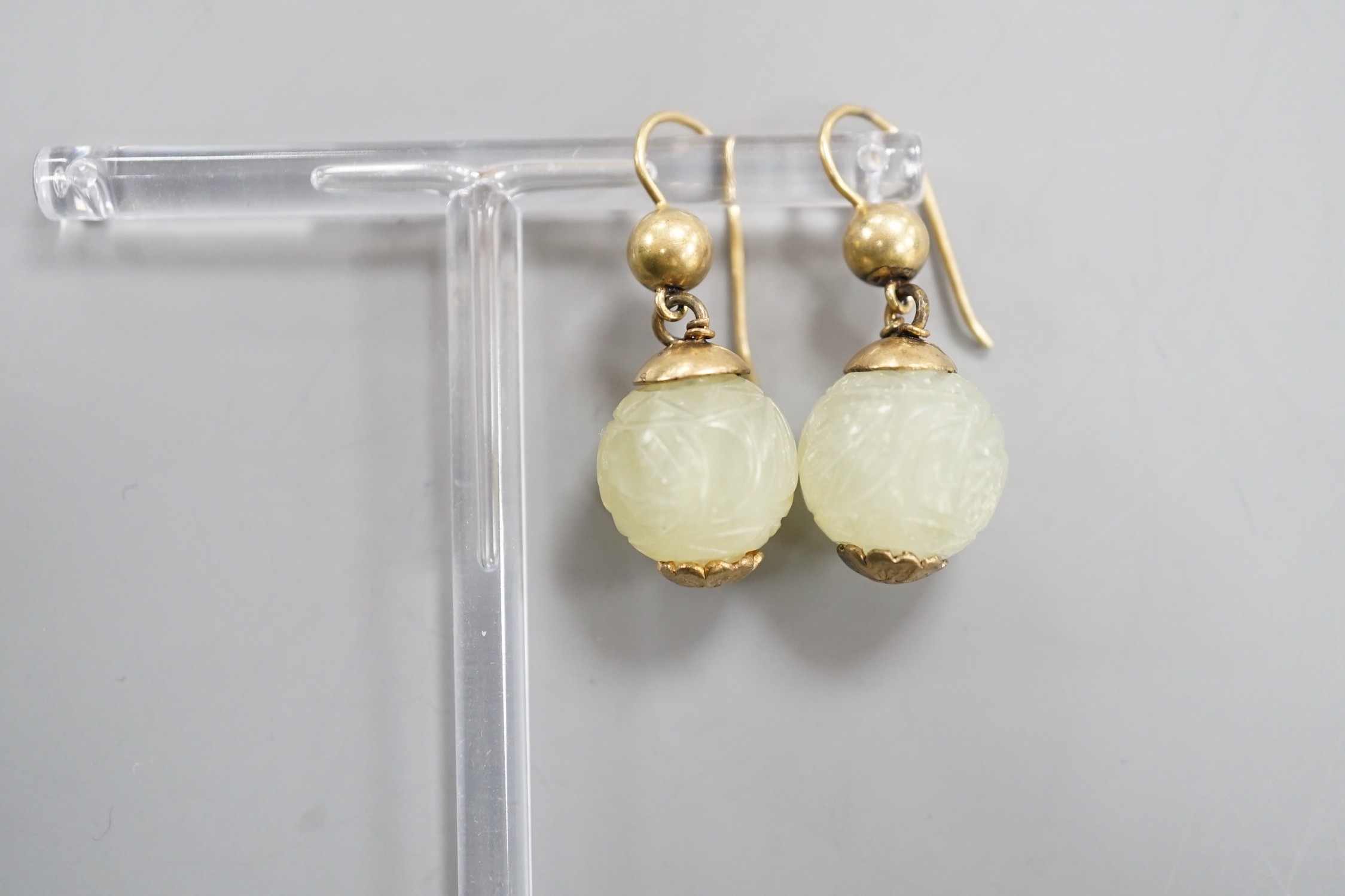 A pair of antique gilt metal and carved hardstone spherical drop earrings, jade diameter 14mm.